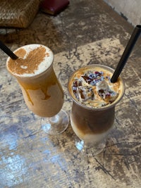 two drinks are sitting on a wooden table