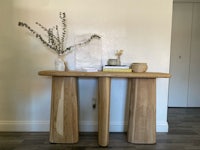 a wooden console table with a vase on it